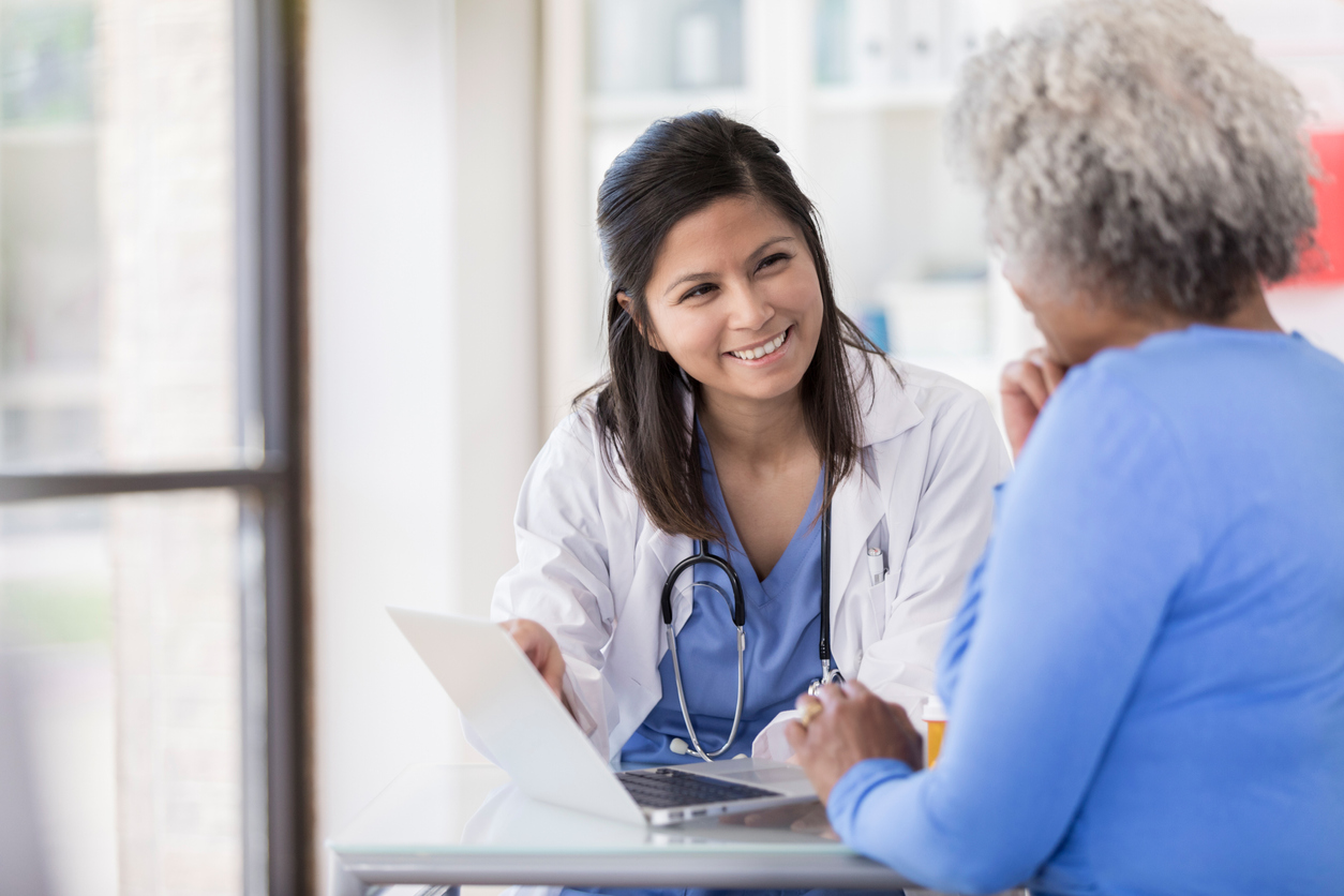 A medical professional talking to an older lady