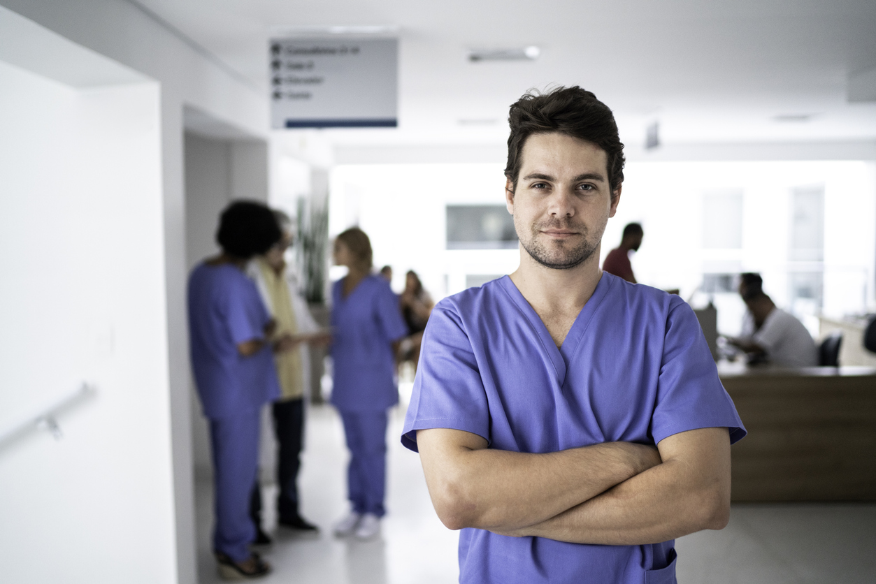 A male medical professional with his arms crossed