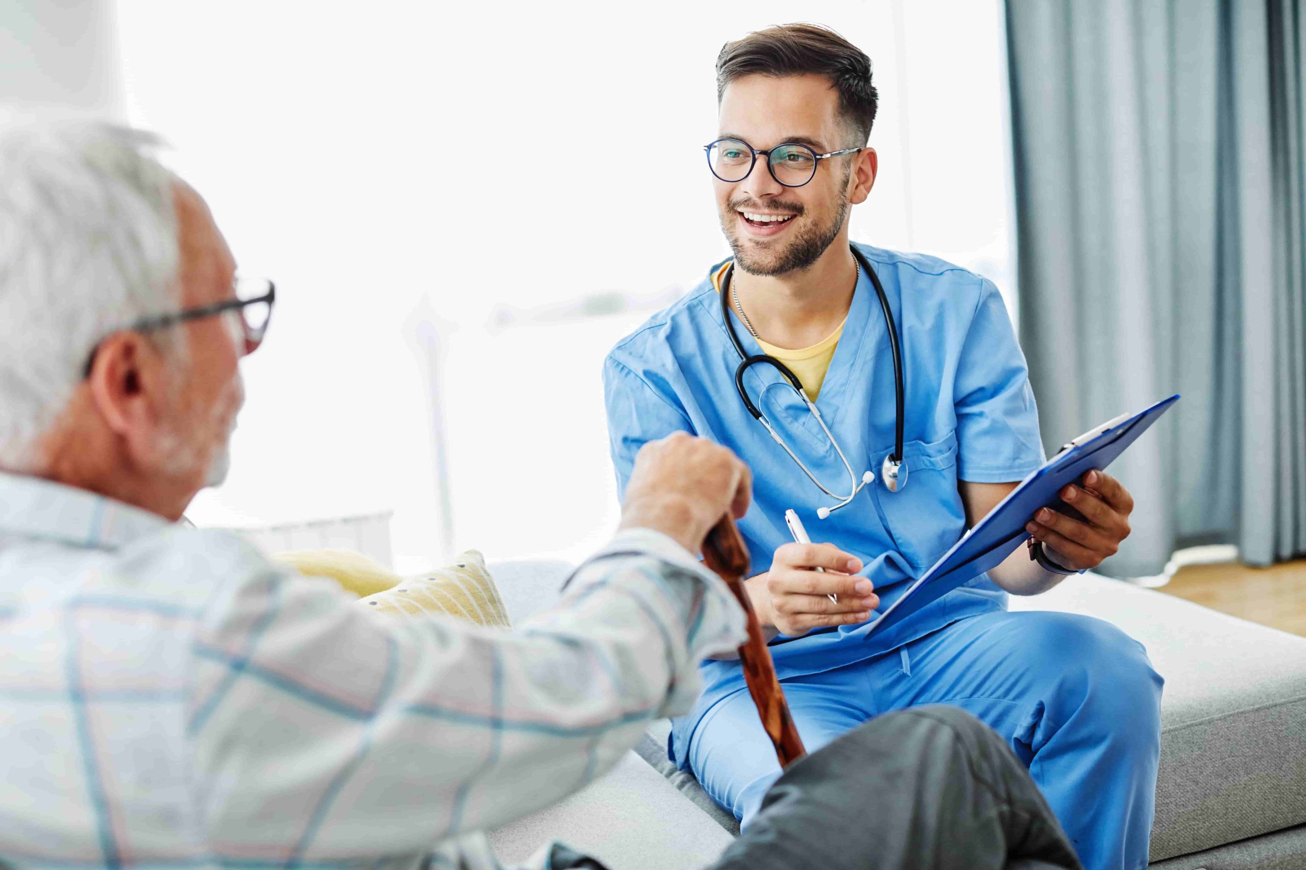 A male medical professional talking to a senior citizen